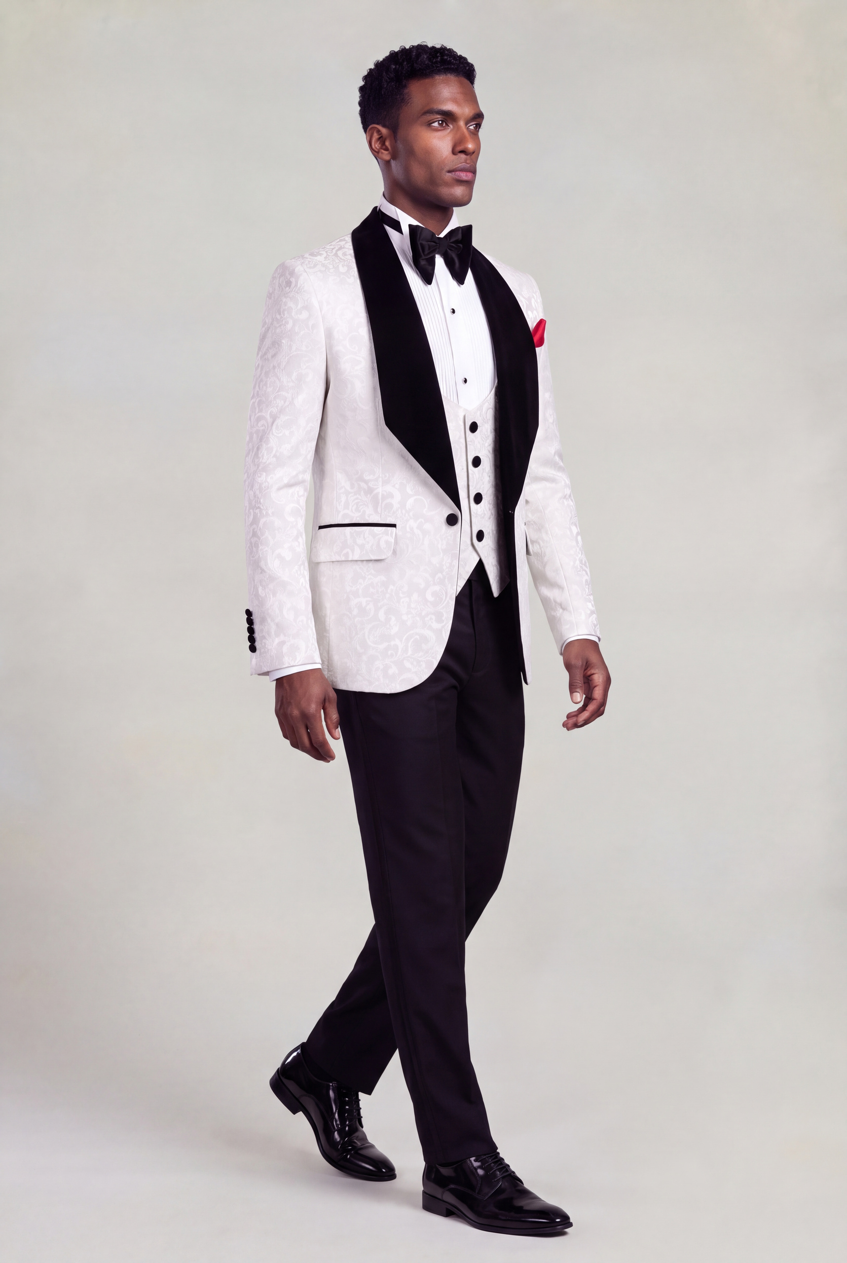 Full-length side walking view of a white damask jacket, four-button vest and black trousers from Gentleman's Guru