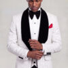 Model adjusting his cuff in a white floral tuxedo with black velvet shawl lapels from Gentleman's Guru