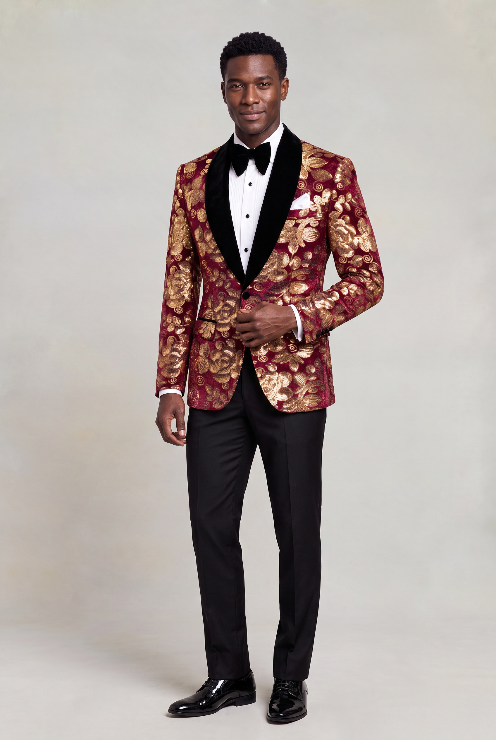 Burgundy and Gold Velvet Tuxedo Jacket full body tailored pose with black bow tie and trousers from Gentlemansguru.com
