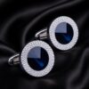 Luxury round blue crystal cufflinks displayed on silk