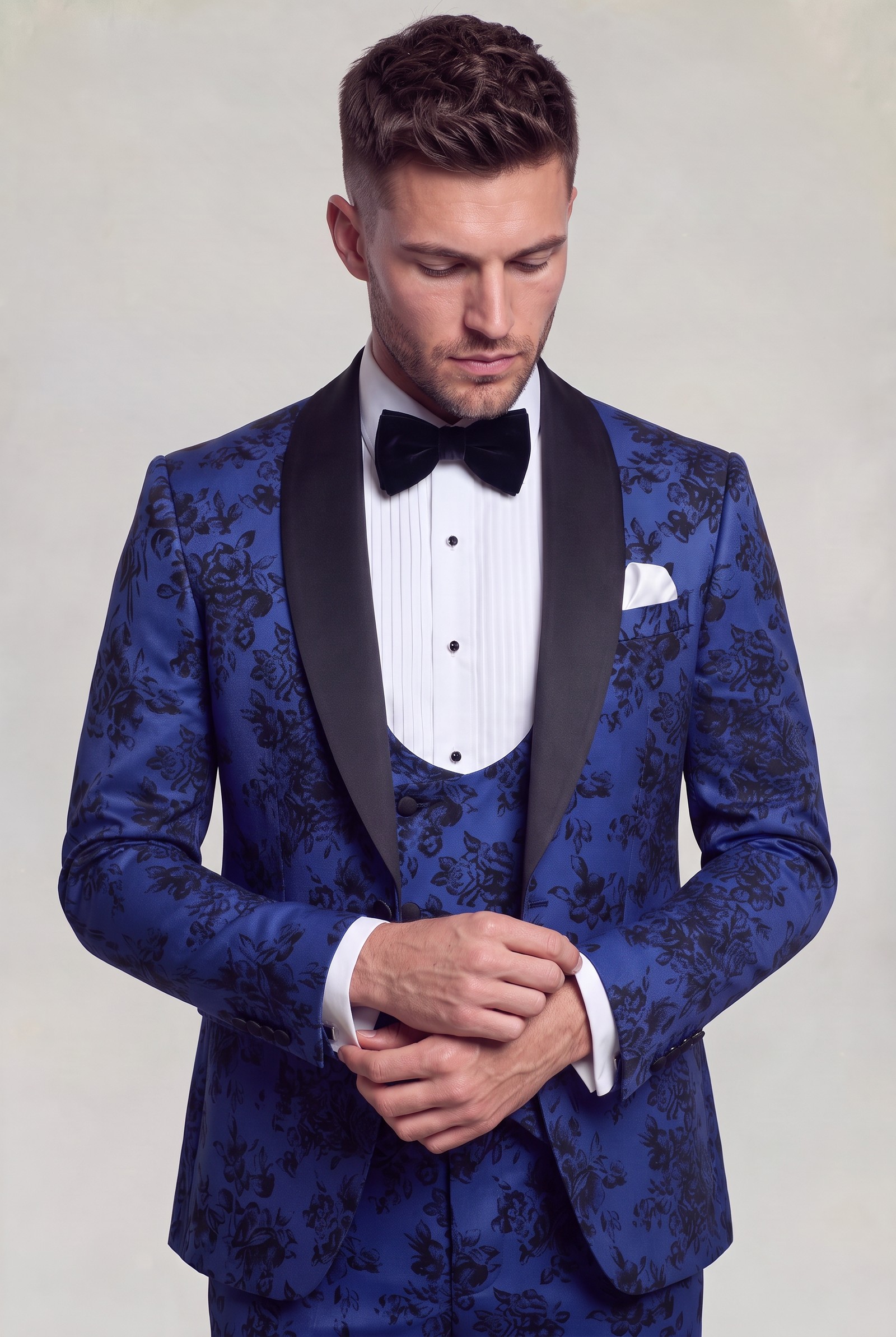 Blue floral tuxedo jacket and matching vest in a cuff-adjusting pose
