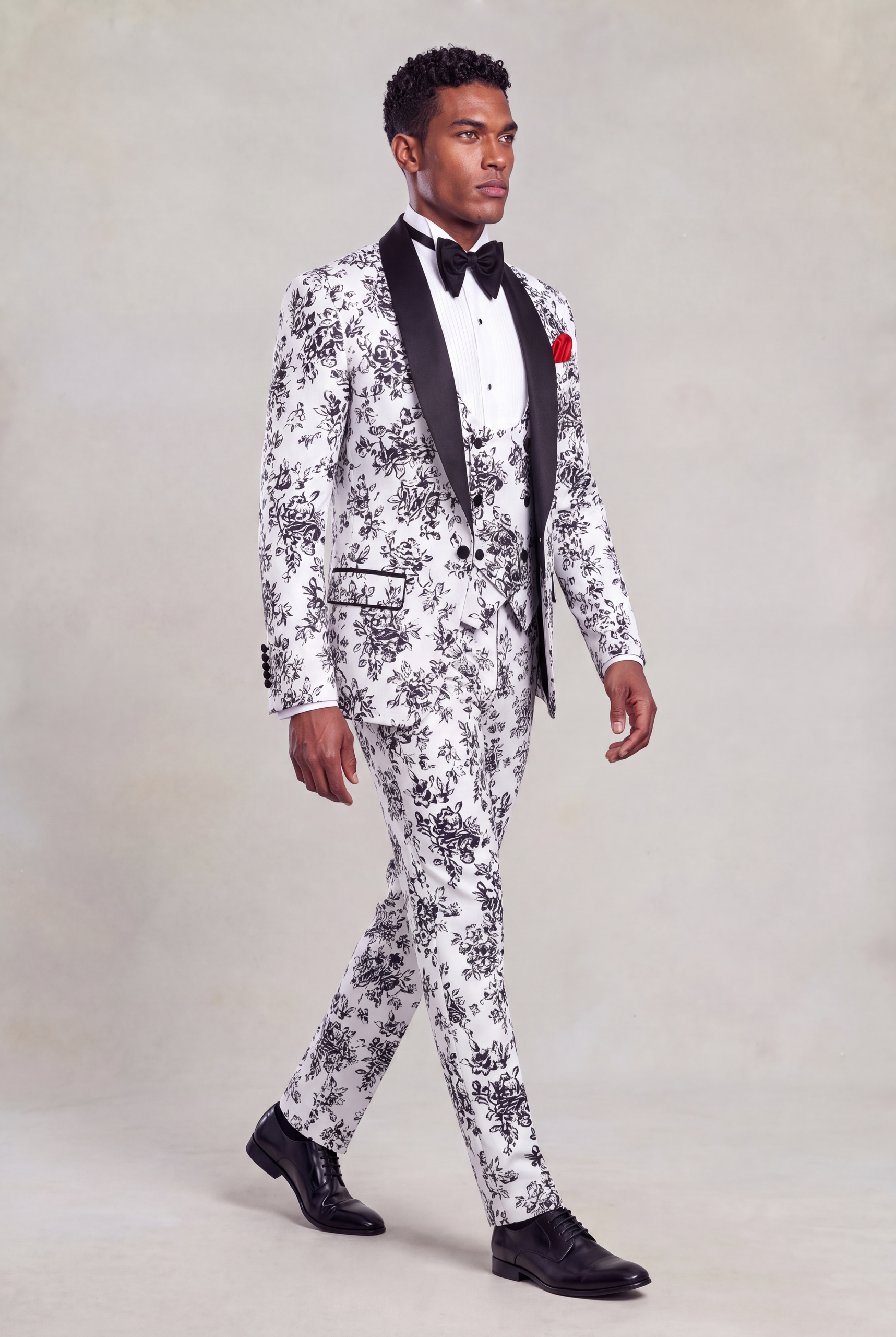 Full-body side walking view of a men’s white and black patterned three-piece suit with black dress shoes from Gentleman's Guru