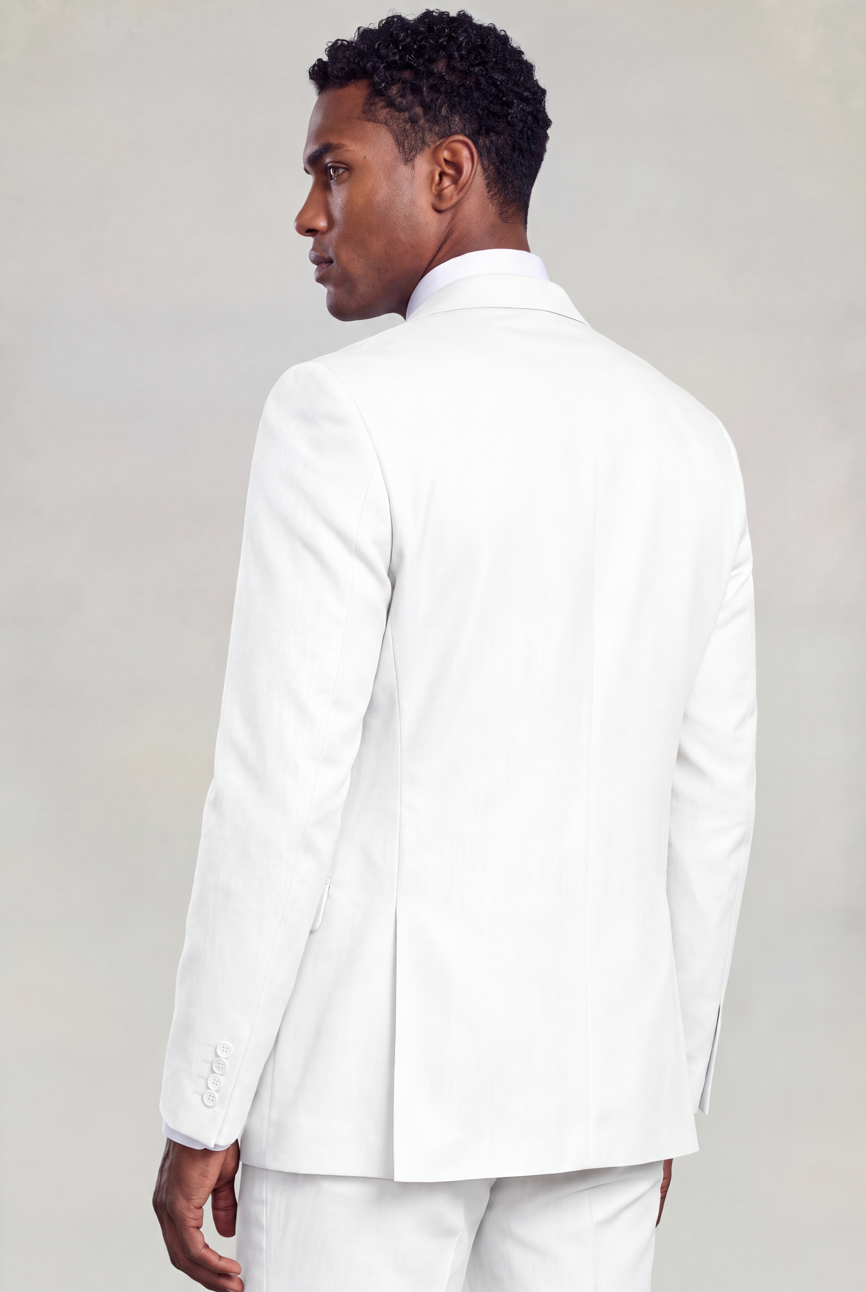 Rear three-quarter view of a plain white suit jacket showing its tailored shape from Gentleman's Guru