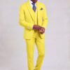 Full-length view of a man adjusting his cuff in a pastel yellow suit with matching trousers and black dress shoes from Gentleman's Guru