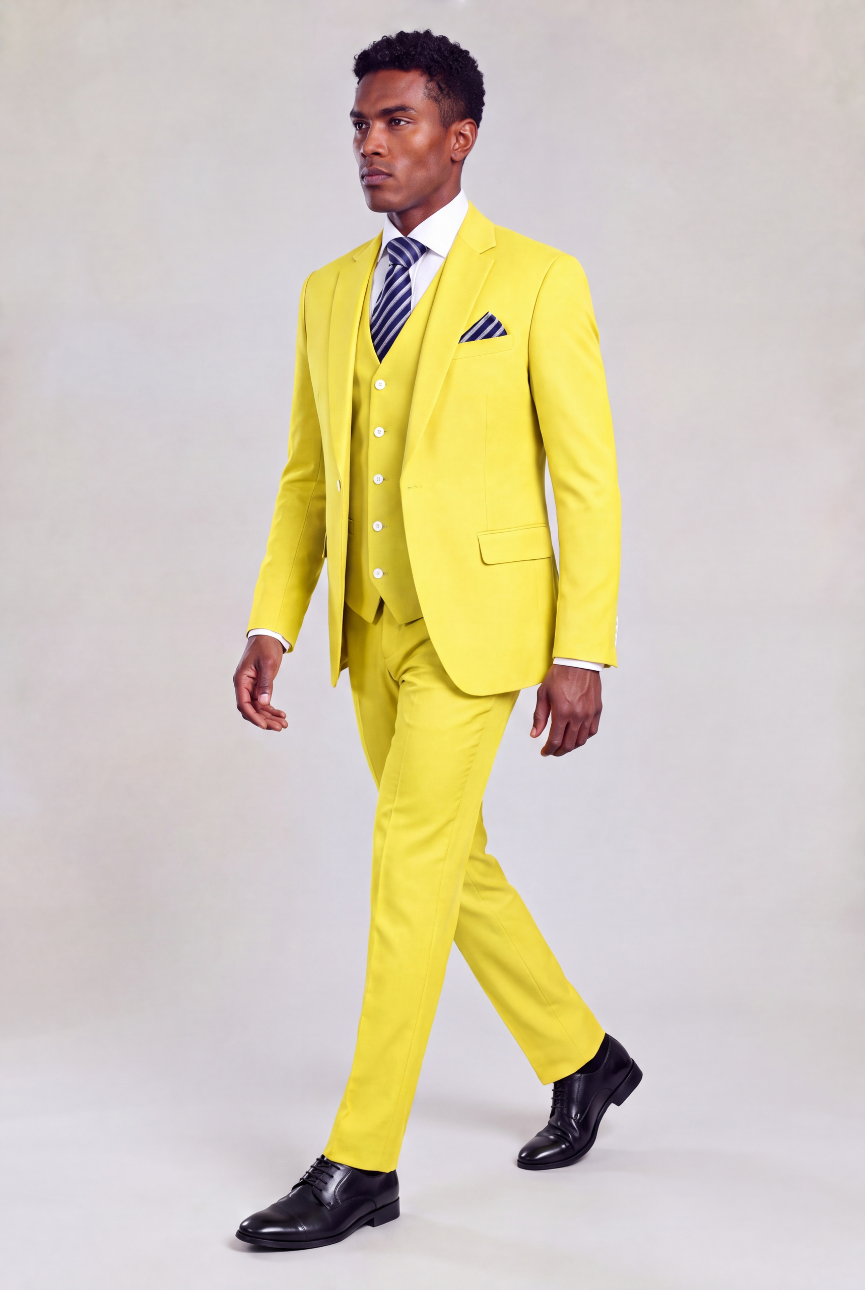 Side walking pose in a yellow suit with matching trousers and black dress shoes from Gentleman's Guru