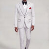 Full-length front walking view of a white polka dot three-piece suit with black dress shoes from Gentleman's Guru