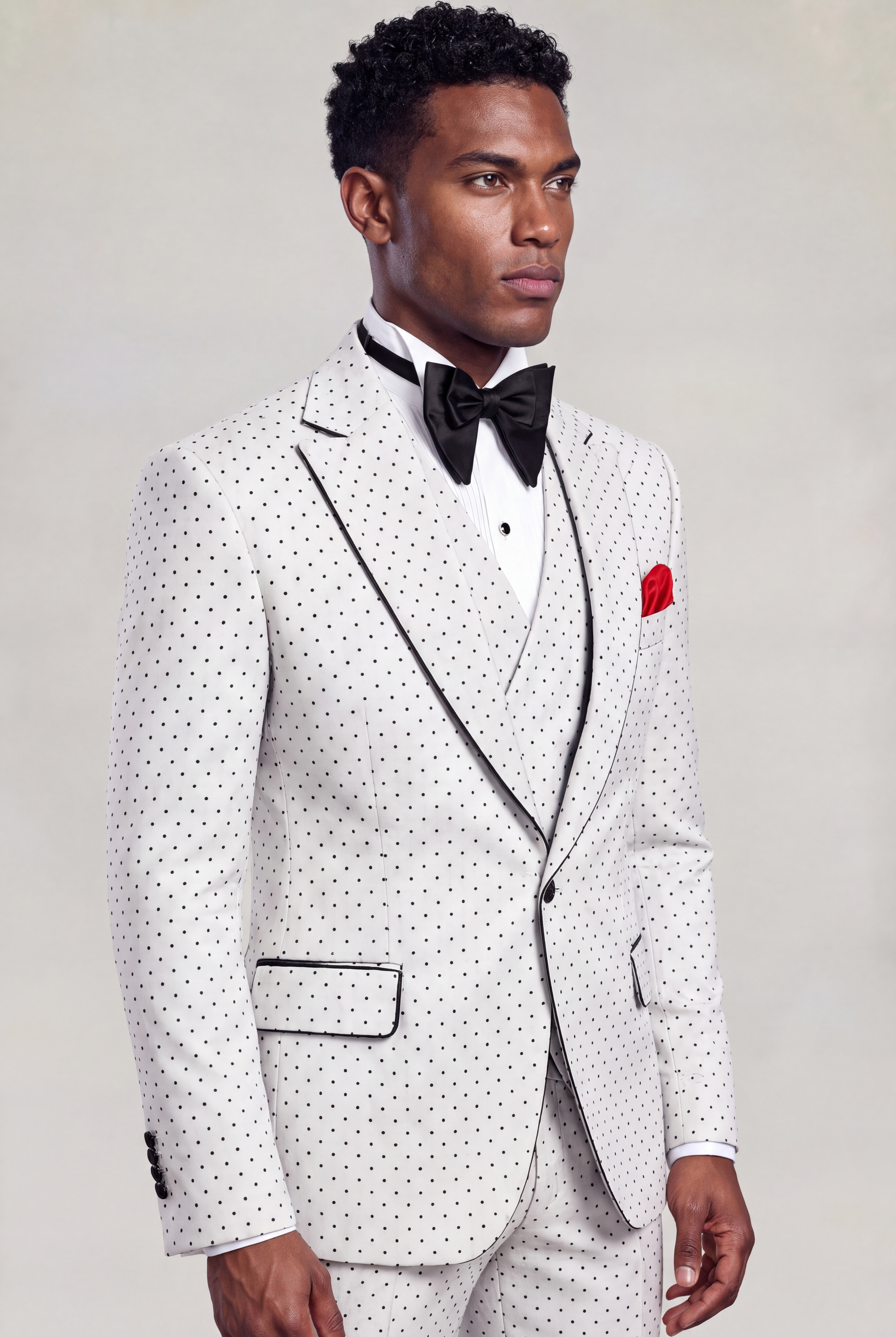 Three-quarter side portrait of a white polka dot suit with black-trimmed lapels and matching trousers from Gentleman's Guru