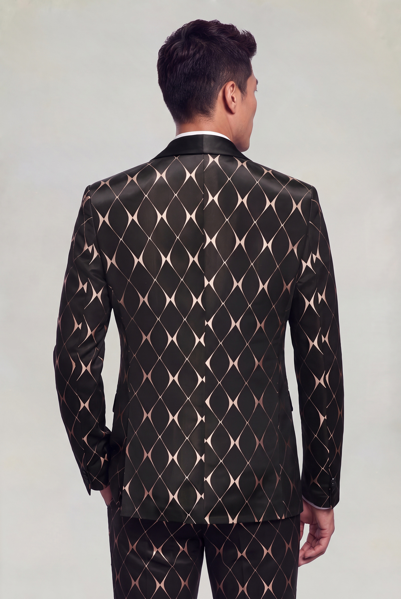 Rear jacket-length view showing the black and rose gold diamond chain-link pattern and black satin back collar