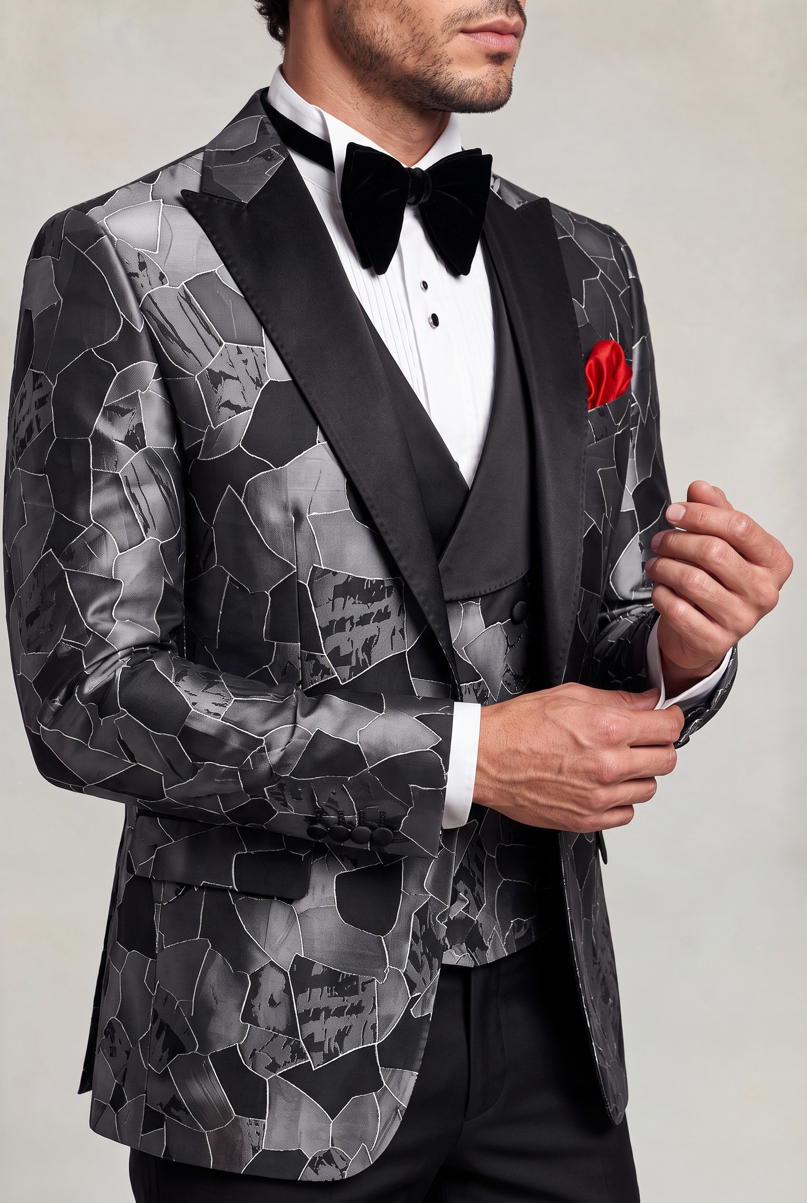 Grey and black tuxedo lapel and fabric detail with cuff-adjusting pose