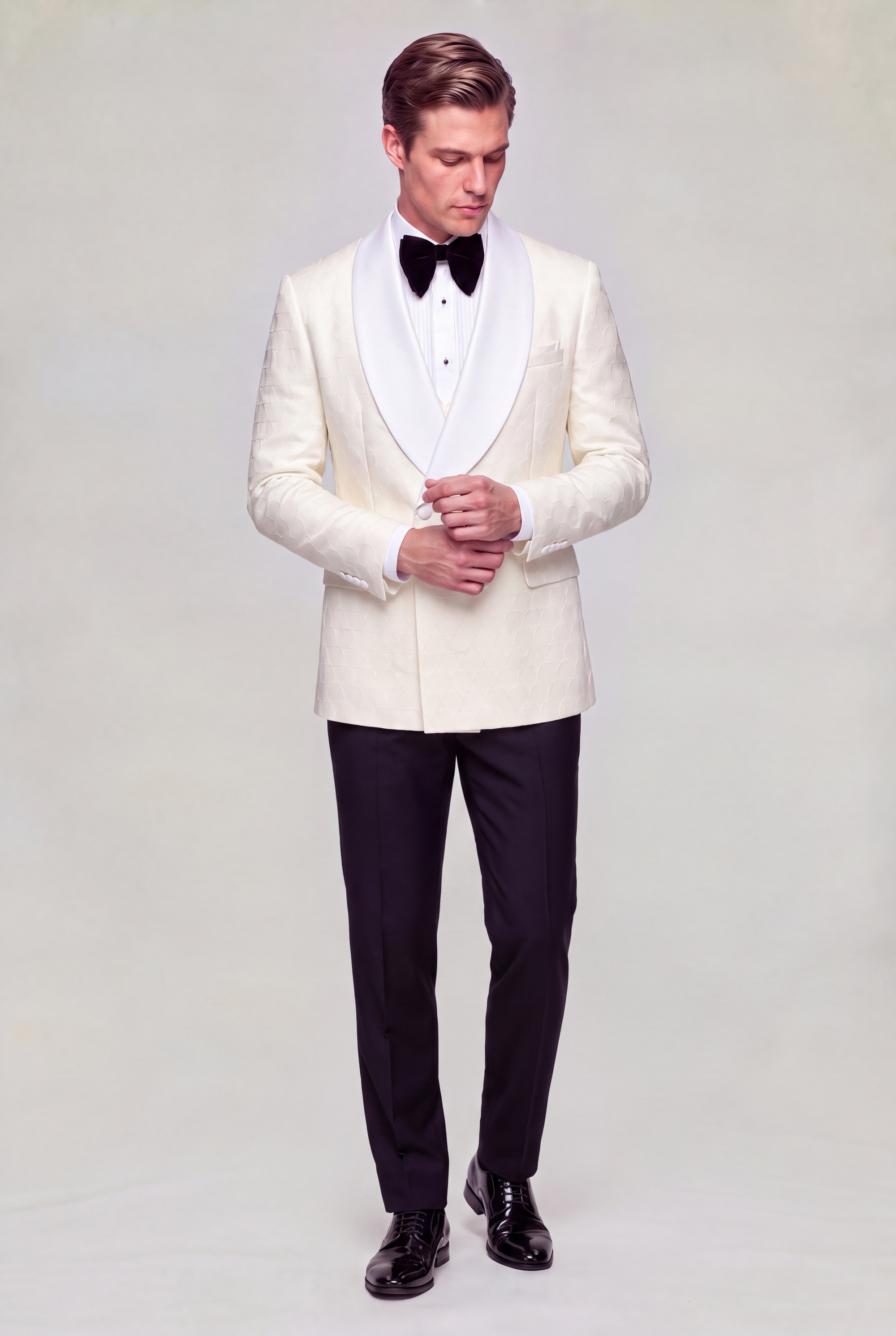 Full body cuff styling pose wearing a cream double breasted tuxedo jacket, black trousers and black dress shoes from Gentleman’s Guru