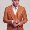 Copper orange windowpane suit in a cuff-adjusting pose