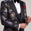 Asian floral tuxedo lapel and woven fabric detail in a cuff-adjusting pose