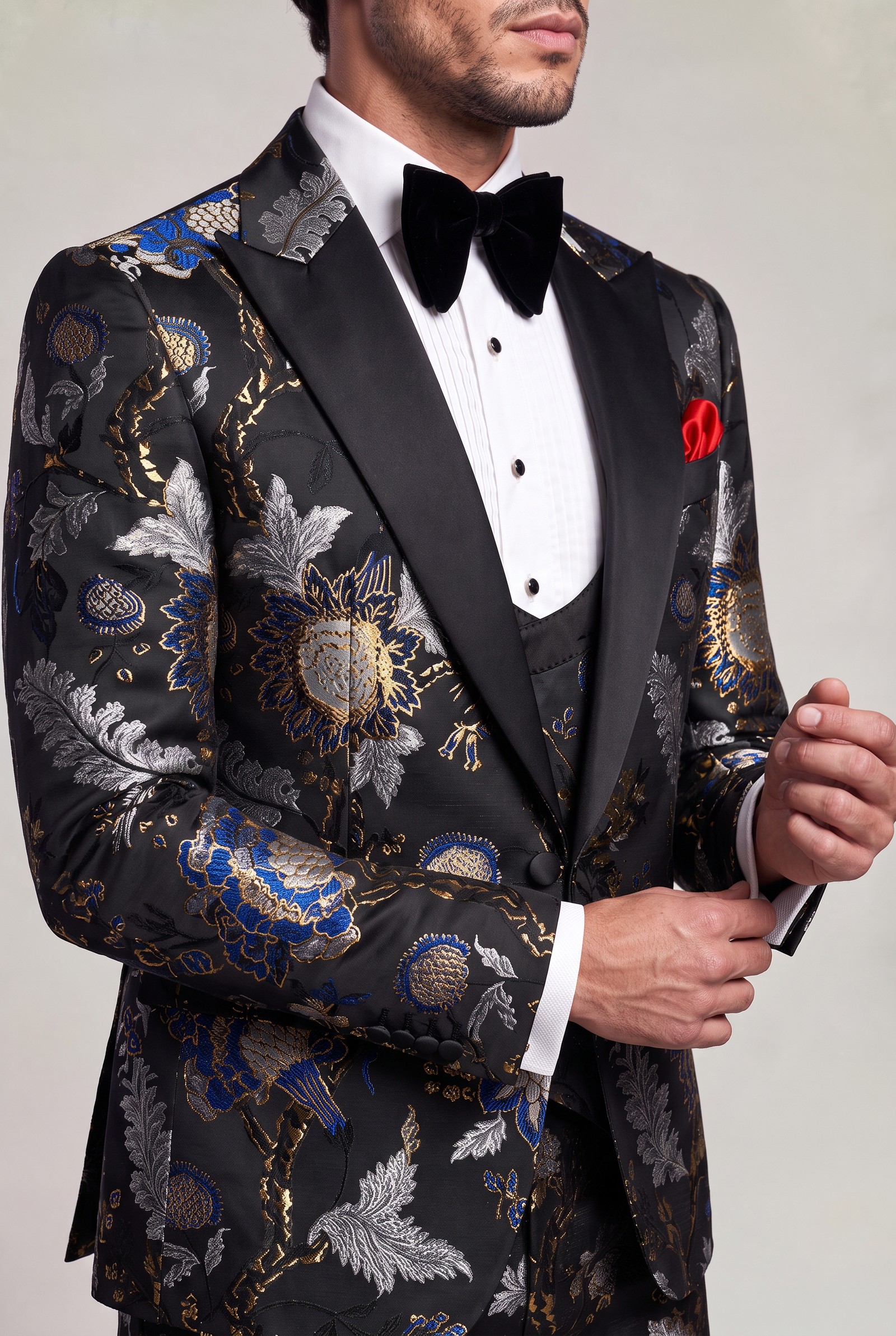 Asian floral tuxedo lapel and woven fabric detail in a cuff-adjusting pose