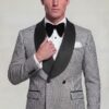 Grey houndstooth double-breasted tuxedo with model holding the black satin lapel