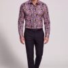 Men’s colorful paisley shirt tucked into black dress pants in a full body walking pose