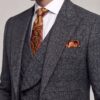 Close-up of dark grey plaid peak lapels with paisley tie and pocket square